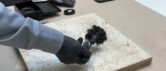 Abnahme von Fingerabdrücken von einer Steinplatte.
