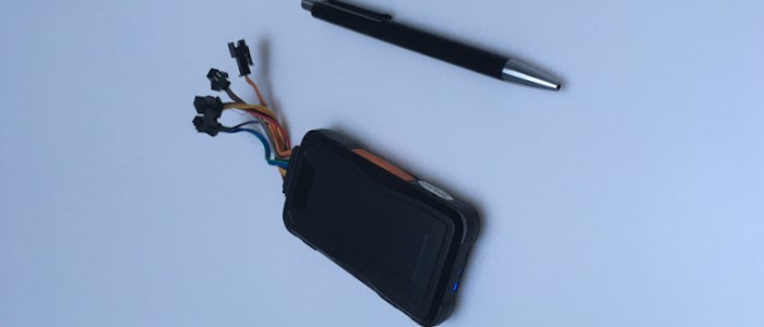 GPS Sender für PKWs und ein Kugelschreiber zum Größenvergleich.