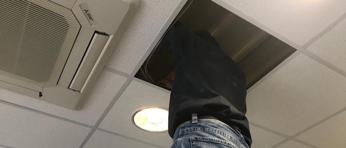 Der Lauschabwehrspezialist überprüft die Deckenplatten in einem Büro.