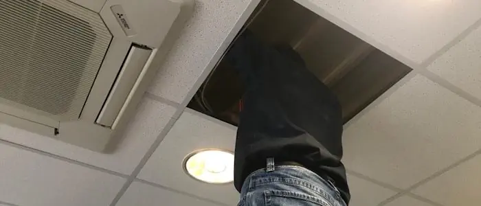 Der Lauschabwehrspezialist überprüft die Deckenplatten in einem Büro.